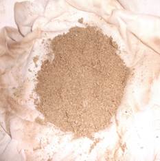 A pile of brown sand on a white cloth

Description automatically generated