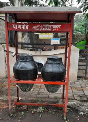 A large black pots on a red stand

Description automatically generated
