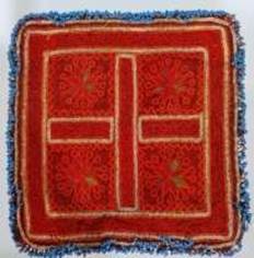 A red pillow with a cross on it

Description automatically generated