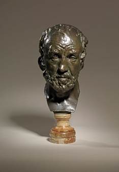A bronze bust of a person

Description automatically generated