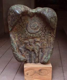 A stone sculpture of a person holding a moon

Description automatically generated